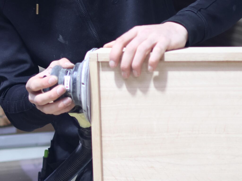 Craftsman sanding bespoke handmade furniture in a workshop